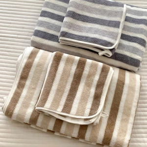 Detailed view of thick striped coral fleece bath towels in grey and brown color options