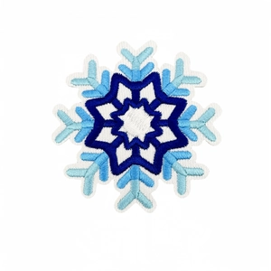 Blue and white embroidered snowflake patch with intricate stitching on white background