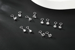 Close-up of S999 sterling silver stud earrings set with butterfly and heart shapes