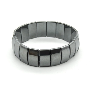 Macro shot of dark grey metallic magnetic hematite bracelet on a white background