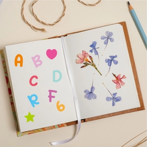 Close-up of 0.5 inch colorful alphabet stickers on a creative journal with dried flowers