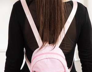 Close-up of pink and white seersucker striped mini backpack with durable fabric texture
