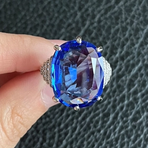 Anello di fidanzamento con zaffiro blu ovale, sei griffe e pavé di diamanti brillanti