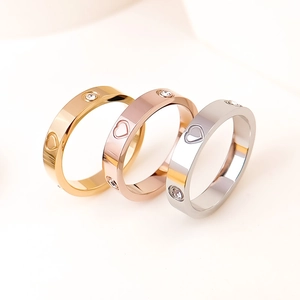 Detail of titanium steel rings with rhinestones and heart cut-outs in three colors