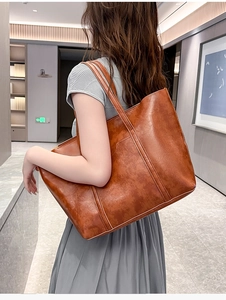 Rear view of a model wearing the brown vintage oil-wax leather tote bag with dual straps