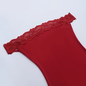 Détail du tissu satiné rouge avec bordure en dentelle délicate et motifs floraux