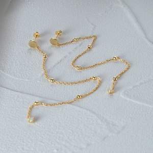 Macro detail of S925 sterling silver gold fringe earrings with opal stone beads
