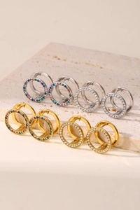 Detalle macro de pendientes de aro con circonitas de colores y chapado PVD en oro y plata