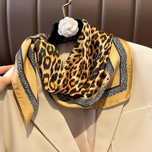 Fashionable leopard print silk square scarf for women styled on a minimalist cream blazer