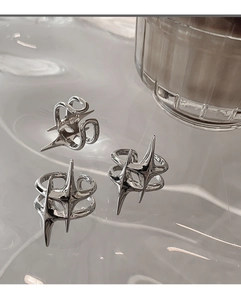 Macro detail of silver star and fluid gothic rings on ripple glass surface