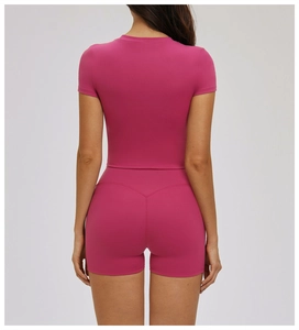 Detail of rose red tight yoga top and high waist shorts with V-shaped back stitching