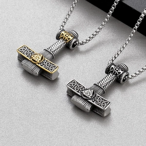 Detailed view of Viking Mjolnir pendants in silver and gold with Celtic knot patterns