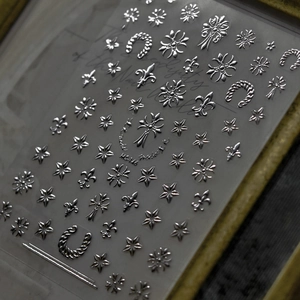 Close-up of silver laser nail stickers with star and cross patterns on WG-16 model sheet