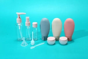 Set da viaggio 11 pezzi con flaconi spray e contenitori in silicone su sfondo ciano