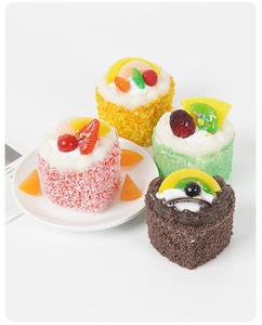 Detail of four colorful heart-shaped mousse cake fridge magnets with realistic toppings