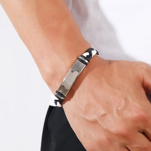 Detail of men's woven leather bracelet with polished metal plate on wrist