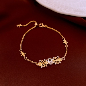 Detailed view of a gold-plated bracelet with an oval gemstone and butterfly motifs