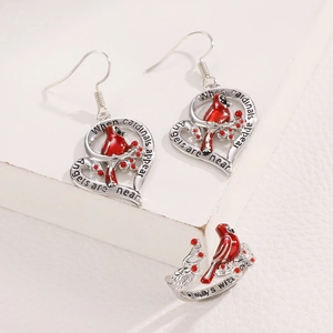 Detailed close-up of cardinal bird jewelry set with engraved heart earrings and ring