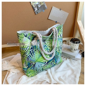 Detail of tropical palm leaf print tote bag with thick rope handles and canvas texture
