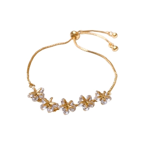 Gold-plated floral bracelet featuring five cubic zirconia flowers on white background