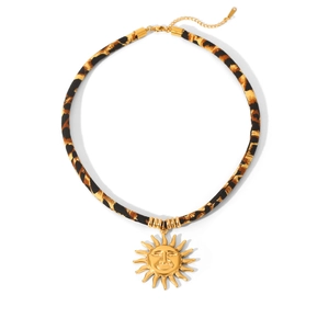 Nahaufnahme der Samtkette mit Leopardenmuster und goldenem Sonnengesicht-Anhänger auf Weiß