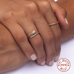 Close-up of S925 sterling silver snake-shaped open ring and slim band on hand