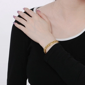 Close-up of golden stainless steel curb chain bracelet worn on a female wrist