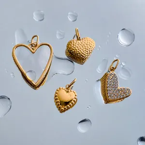 Collection of four gold heart-shaped stainless steel pendants with various artistic textures