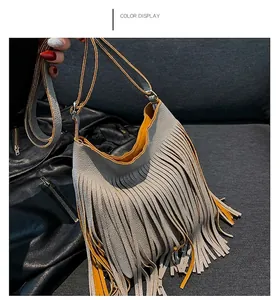 Close-up of a grey leather tassel bag with a vibrant orange lining and fine strap