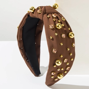 Detail of dark brown knotted headband with gold metal beads and pink rhinestones