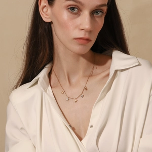 Close-up of golden starfish pendant necklace worn by a female model with soft lighting