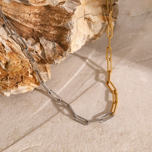 Minimalist two-tone stainless steel chain necklace in gold and silver on a rock