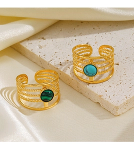 Detail of adjustable gold rings with green malachite and blue turquoise on silk fabric