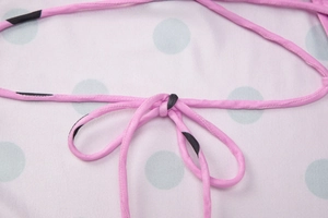 Détail des lanières roses à nouer et rayures noires sur robe dos nu à pois