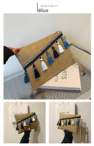 Detail of bohemian linen envelope clutch with blue tassels and ethnic woven strap accent