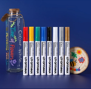 Set of 8 colorful oil-based paint markers showing usage on glass and wood surfaces