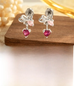 Detail of silver bow cartilage stud with pink teardrop and rose heart zirconia stones