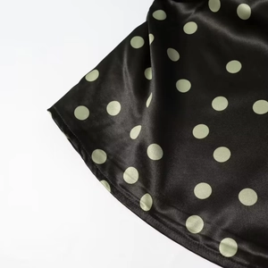 Makroaufnahme der Satin-Stoffdetails mit Punkten für die Schlaghose und das Halfter-Top