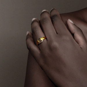 Macro detail of geometric two-tone ring in gold and silver plating on model hand