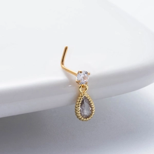 Golden nose stud with round clear zircon and drop-shaped gray pendant on white background