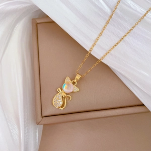 Close-up of golden cat pendant with opal gemstone and sparkling zircon micro-pave
