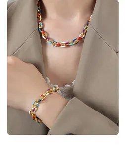 Detail of colorful enamel gold chain necklace and bracelet set on a fashion model