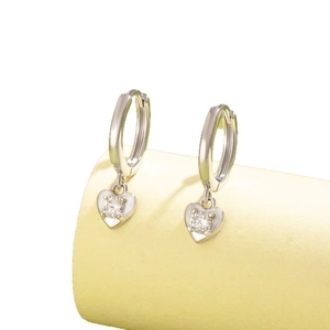 Boucles d'oreilles cœur en zircon argenté sur un support d'exposition minimaliste