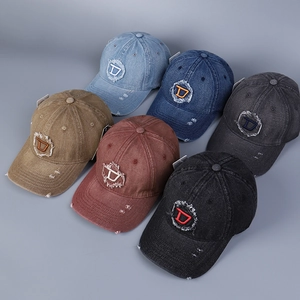 Dettaglio dei cappellini da baseball in denim lavato in vari colori con toppa a D