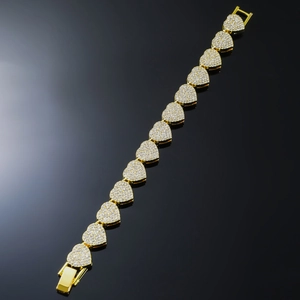 Detailed close-up of golden heart link bracelet with full diamond inlay and clasp