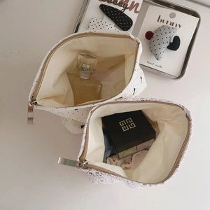 Detail of floral and polka dot makeup pouches showing interior capacity and zipper closure