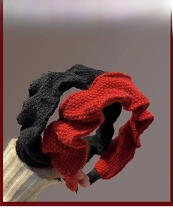 Detail of red and black knitted wavy headbands featuring thick winter fabric texture