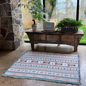Detail of bohemian woven blanket with geometric patterns and fringe edges