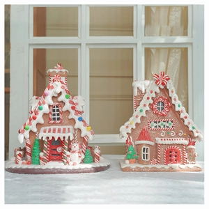 Close-up of a pair of festive gingerbread houses with snow effect and holiday decorations