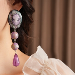 Detail view of purple vintage resin portrait earrings with elegant water drop pendants